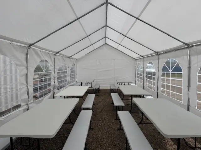 Tables et bancs sous une tente de réception